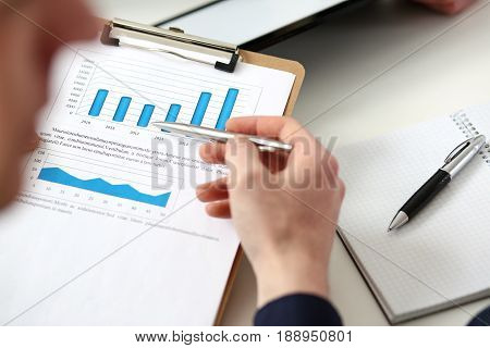 Male Hands Hold Clipboard Pad With Financial Statistics