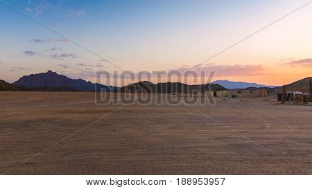 Wonderful landscapeArabian desert of stone Egypt with mountains at sunset.To the right of the desert nomad huts
