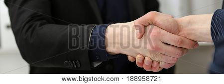 Two Businessman Shake Hands As Hello In Office Closeup