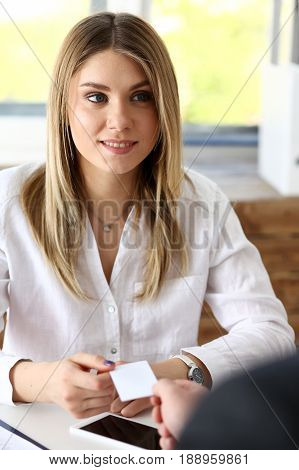 Smiling beautiful woman give blank calling card to male visitor. White collar partners company name exchange executive or ceo introducing at conference product consultant sale clerk concept