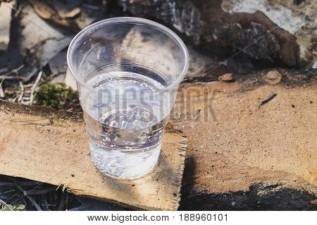 Plastic glass of mineral water on the ground