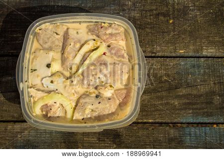 Marinated pork meat on wooden table outdoor. Top view