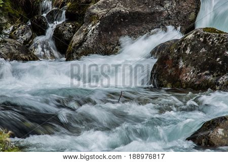 Nature scene.Forest stream running over mossy rocks.