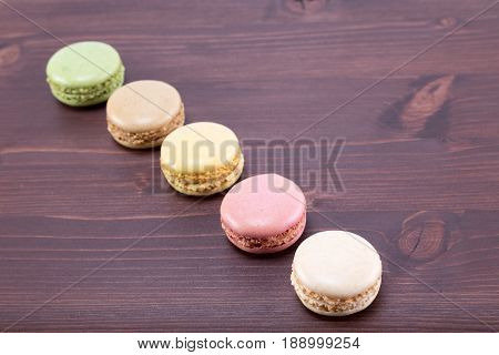 Tasty And Colorful Macarons On A Natural Ipe Wood Dark Brown Table