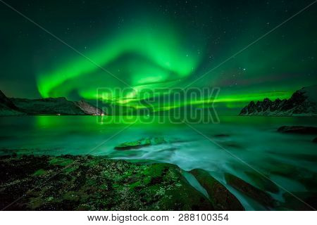 Aurora Over Ersfjord And Tugeneset Rocky Coast With Mountains In Background, Norway