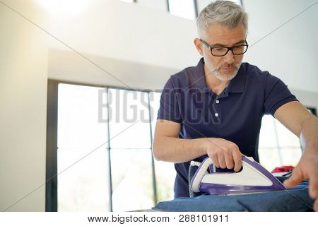 Man ironing shirt in stunnig modern home