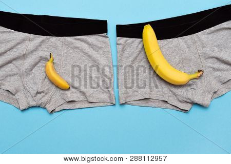 Baby Banana Compare Size With Big Banana On Male Panties On Blue Background.
