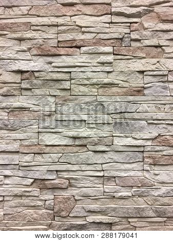 Artificial Stone. Decorative Wall Of Artificial Torn Stone. Stone Masonry In Geometric Pattern As Ba