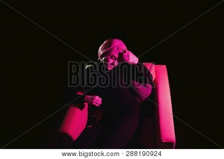 Fashion Woman Pink Hair On The Armchair . Pink Light. Life Style. Retro Wave Neon Noir Lights Color 