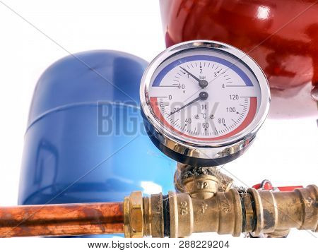 Pressure gauge mounted on copper piping system with expansion tanks in house boiler room