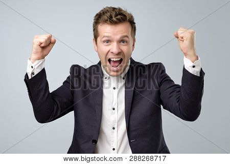 Happy Excited Man In Suit Screaming And Celebrating Succcess With Two Fists Up