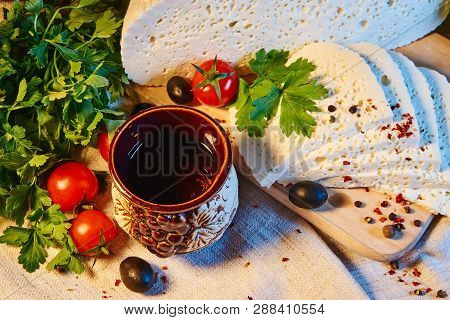 Homemade Georgian Imeretian Cheese On A Wooden Board, Cherry Tomatoes, Walnuts, Grapes, Spices