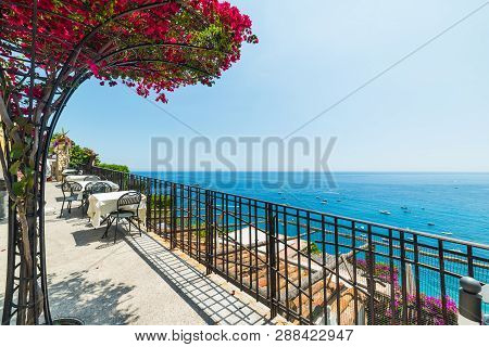 Tables And Chairs Anad Bougainvillea Flowers On Positano Seafront. Amalfi Coast, Italy