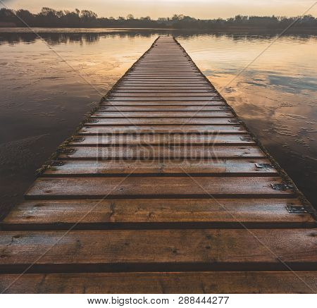 A Dangerous Frozen Wooden Walkway Leads Out Into The Middle Of A Lake