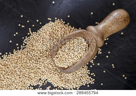 Quinoa Grains With Spoon And Bowl On Black Background