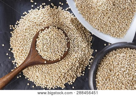 Quinoa Grains With Spoon And Bowl On Black Background