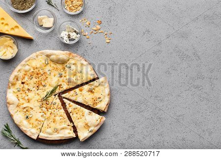 Pizza Quattro Fromaggi Cutted Into Slices On Grey Table, Top View