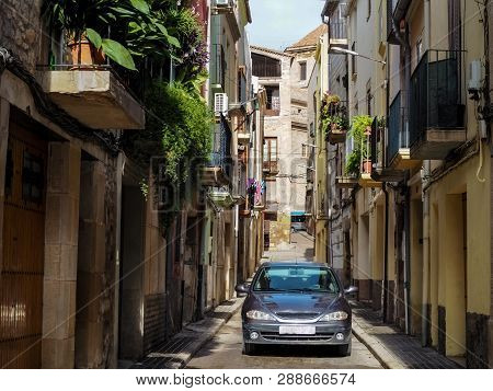 Modern Car On A Narrow Street In A Residential Area In Tarrega (catalonia, Spain). The Contrast Betw