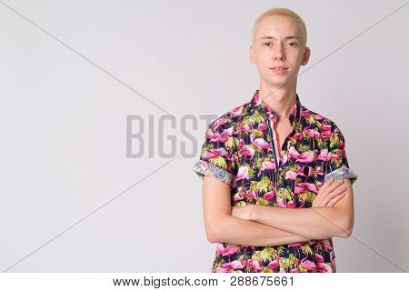 Young Happy Androgynous Tourist Man Smiling With Arms Crossed
