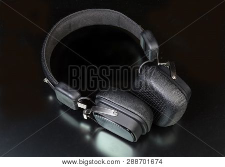 Black Wireless High-fidelity Ear Speakers On A Dark Surface