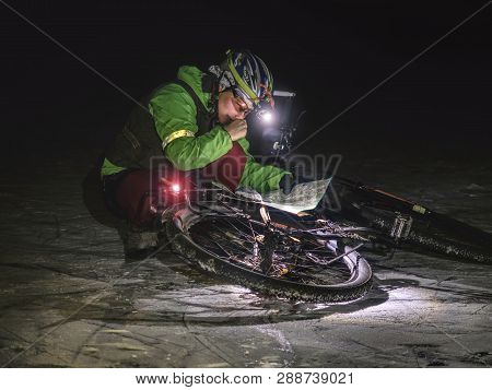 Extreme Winter Mtb Orienteering Race. Biker Check The Paper Map And Own Possition In Landscape