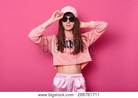 Trendy Beautiful Long Haired Young Model With Black Rounded Glasses, Rose Street Clothes Posing On P
