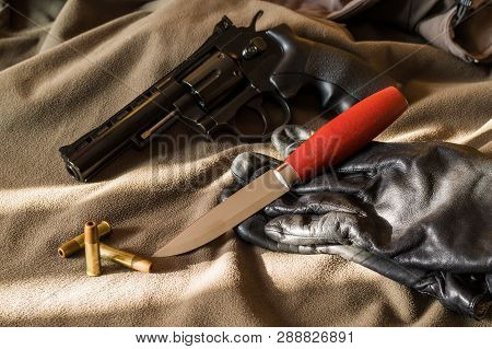 Pistol, Knife And Gloves. Pistol And Bullets. Light And Shadow.