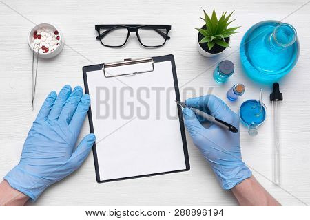 Medical Examination Mockup. A Doctor Or Pharmacist Is Writing A Notes To A Blank Paper Sheet With A 