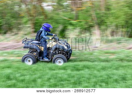 The Boy Skates On A Quad Bike In A Beautiful Area.
