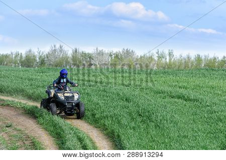 The Boy Skates On A Quad Bike In A Beautiful Area.