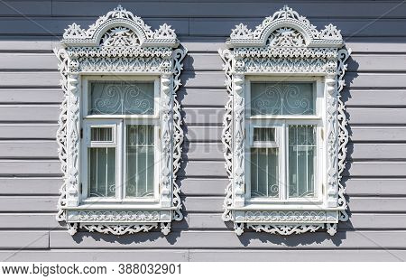 Russian Traditional Wooden Architecture. Facade Of An Old House Decorated With Wooden Carvings, Plat
