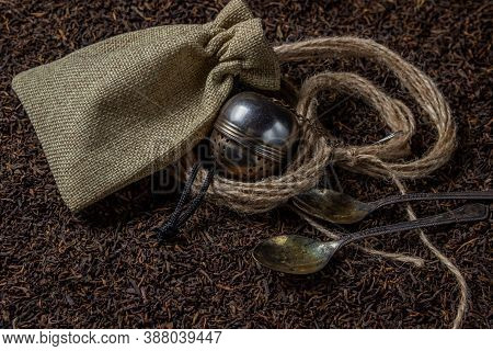 Leaf Tea. A Lot Of Loose Tea. Teaspoons, A Pouch And A Tea Ball Lay On Loose Tea