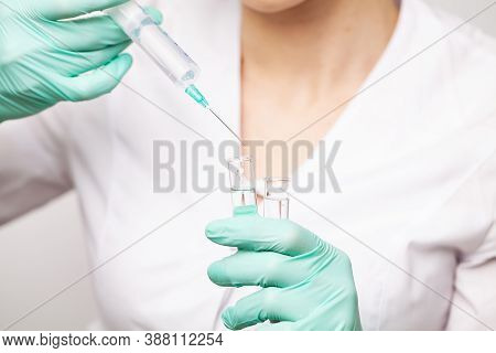 Hands Of The Doctors Filling A Syringe