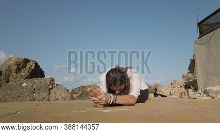 Young Woman Practising Yoga, Split Position Holding Her Feet. . High Quality Photo