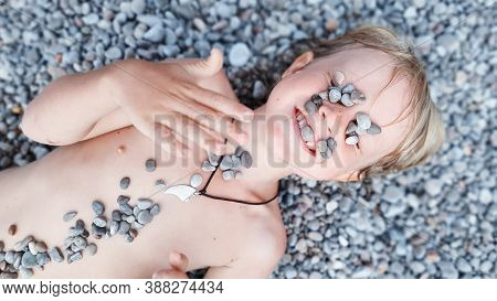 On Sunny Beach Happy Kids Have Fun, Lying Down On Hot Pebble, Sunbathing, Warming After Swimming In 