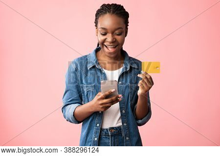 Mobile Shopping App. Cheerful African American Woman With Smartphone And Credit Card Making Online P