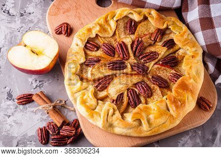 Crispy Apple Galette With Pecans On A Rustic Wooden Background