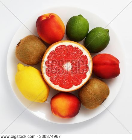 Fresh Fruit Mix On A Plate. White Background. Grapefruit, Lime, Nectarine, Lemon, Kiwi. Top View