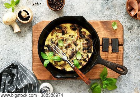 Frittata With Mushrooms In A Pan With Basil On A Concrete Background. Fritata Is An Italian Breakfas