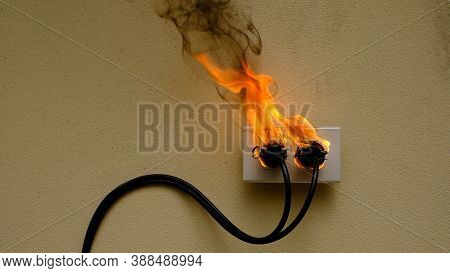 On Fire Electric Wire Plug Receptacle On The Concrete Wall Background