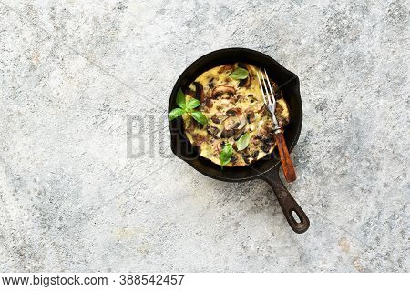 Frittata With Mushrooms In A Pan With Basil On A Concrete Background. Fritata Is An Italian Breakfas