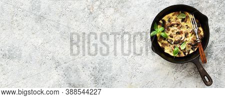 Frittata With Mushrooms In A Pan With Basil On A Concrete Background. Fritata Is An Italian Breakfas