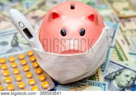 Piggy Bank In A Mask On A Background Of American Currency.the Concept Of Coronavrius Epidemic