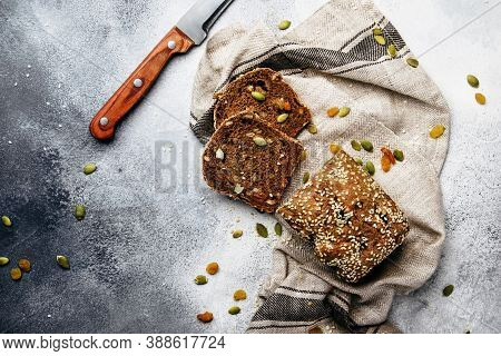 Whole Wheat Organic Rye Dark Bread With Pumpkin Seeds, Dried Fruit, Raisins And Sesame Seeds On Gray