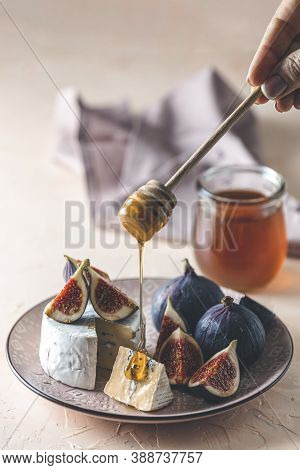 Sweet Honey Dripping From Blue Or Bleu Cheese With Fig And Honey Or Maple Syrup On Pink Plate. Tasty