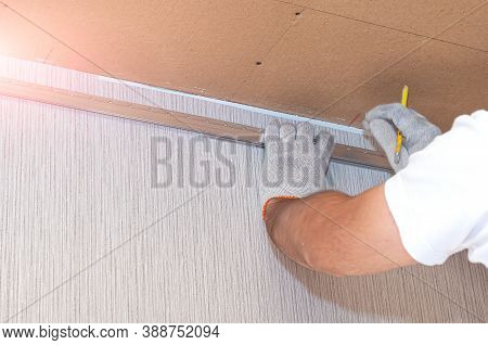 Fastening To The Wall Guide For Stretch Ceiling. Repairers Make Installation Of A Stretch Ceiling. W