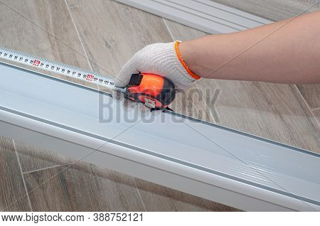 Worker Measures A Profile For Led Lamp For Stretching Ceiling, Construction Work, Repair. Renovation