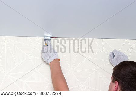 Process Of Installing Stretch Ceiling In The Hall. Close Up Of The Hand Of Man With A Tool.