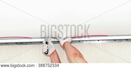 Process Of Installing Stretch Ceiling In The Hall. Close Up Of The Hand Of Man With A Tool