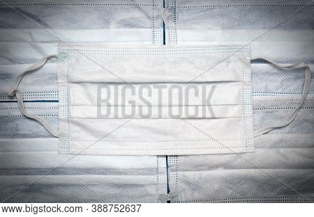 White Disposal Medical Maskon Background Made Of The Same Masks. Top View. Vigneted Image.